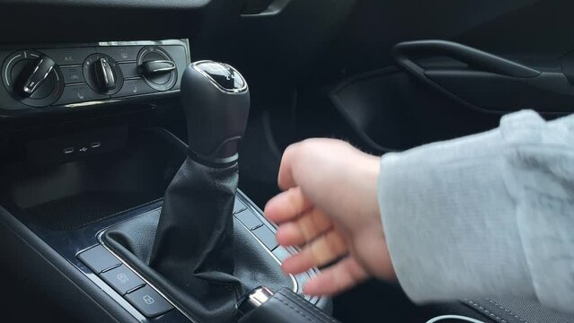 Releasing hand or parking brake and shifting first gear, car interior low angle close up view