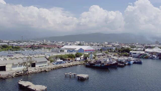 Aerial view of the old dock and waterfront in Kinston Jamaica with the camera turning right with a seagull in flight