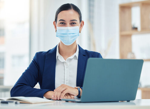 Compliance, face mask and covid rules at work with a business woman working on a laptop in a corporate office. Portrait of a female practice social distancing at workplace, regulations and hygiene