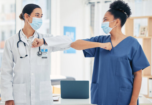 Woman Doctor And Nurse, In A Hospital Elbow Greeting, In Surgical Mask During The Covid Pandemic. Teamwork, Healthcare Worker And Medical Professional With Protection From Virus During Consultation