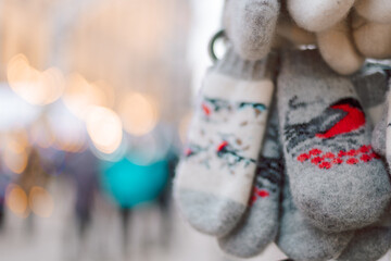 Christmas decoration at the New Year's fair. Winter knitted mittens for hands with bullfinches birds, selective focus. High quality photo