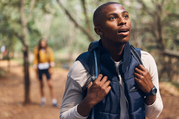Hiking young black man in forest nature with wow face traveling with backpack in woods. Surprise,...