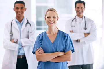 Portrait of medical doctors with crossed arms with a stethoscope standing in the hospital hallway. Happy healthcare workers after clinic trial, surgery or consultation success at a medicare center.