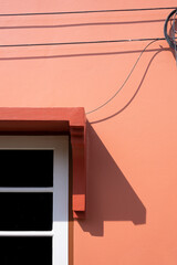 Minimal background of electrical and internet cable lines neatly mounted on exterior wall of brown house in vertical frame