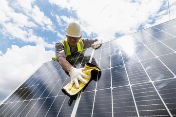 Engineer cleaning solar panels Hand wipe the solar panel from dirt.Cleaning mini photovoltaics which installed beside