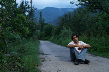 Fototapeta premium person sitting on the rocks