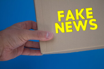 Fake News word with cardboard box. Brown folded cardbox.