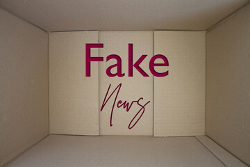 Fake News word with cardboard box. Brown folded cardbox.