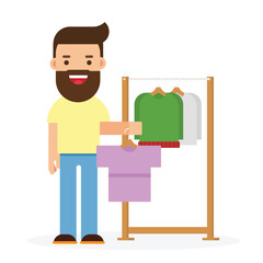 Young man chooses clothes on hanger on shopping