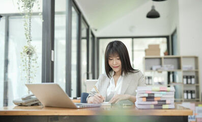 Asian businesswoman using calculator and financial documents at the table office, business financial concept.