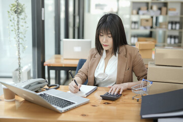 Asian businesswoman using calculator and financial documents at the table office, business financial concept.