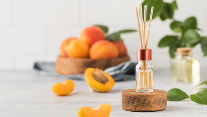Interior perfume with the scent of apricots. Jar with aroma oil and banbu sticks