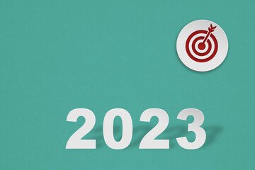 year 2023 text paper cut with red dart board on grunge green background for annual plan concept