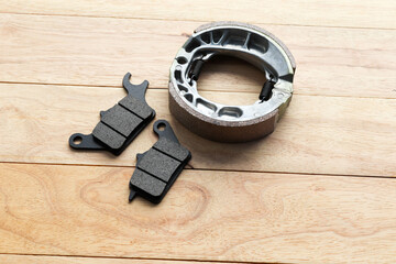 Front and rear brake pads for the motorcycle brakes isolated on wooden background closeup.