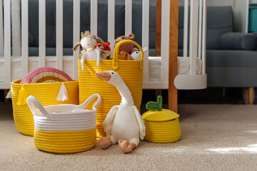 Yellow Toy Storage Baskets in the children's room. Cloth stylish Baskets with toys. Organizing and...