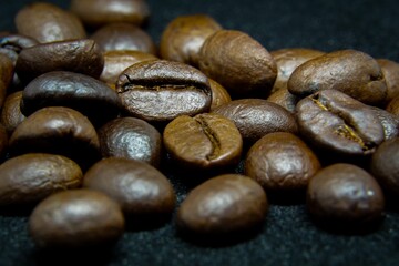 The way coffee beans lay on a black background, elegant and delicious coffee beans and the aroma of morning coffee.