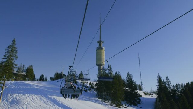 Main chairlift at Oslo vinterpark with skiers, Tryvann tower, Winter Park ski resort