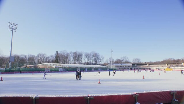 Young adults, teenagers ice skating and playing hockey at Frogner park in Oslo, Norway