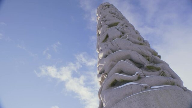 The Vigeland exhibition at Frogner park, central tower looking up shot on a sunny with clouds, snowy winter day