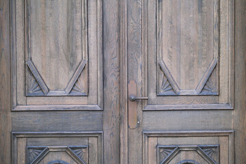 Closed old textured wooden door with handle 