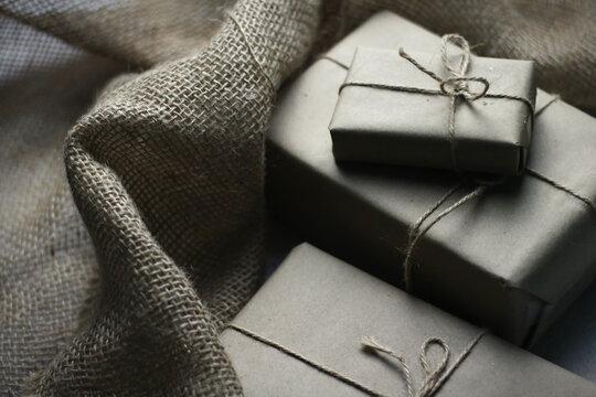 Gift box wrapped in brown recycled paper placed on a white table