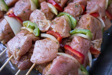Close up of skewers with juicy meat and vegetables. Raw kebab from pork meat with vegetables.