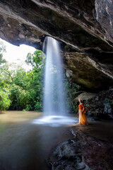 Woman standing in Saeng Chan Waterfall at Pha Taem National Park, Ubon Ratchathani, Thailand.
