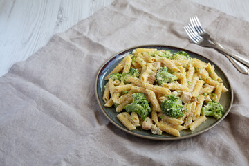Homemade Penne Alfredo Pasta with Chicken and Broccoli on a Plate, side view. Copy space.