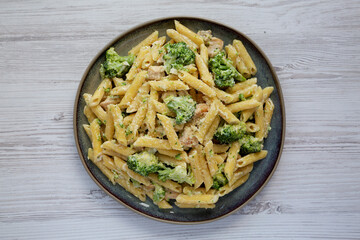 Homemade Penne Alfredo Pasta with Chicken and Broccoli on a Plate, top view. Flat lay, overhead, from above.