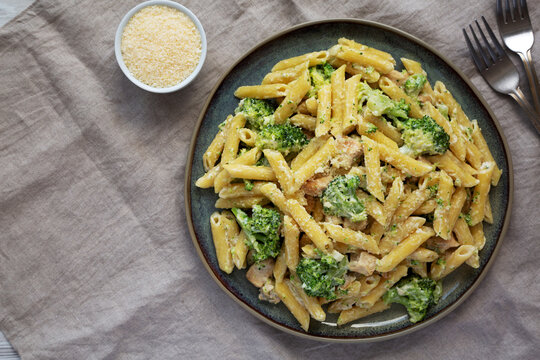 Homemade Penne Alfredo Pasta with Chicken and Broccoli on a Plate, top view. Flat lay, overhead, from above.