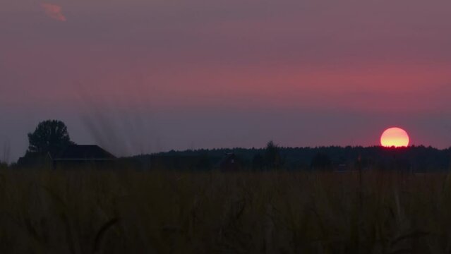 Timelapse of sun setting in countryside. Picturesque sunset over village.