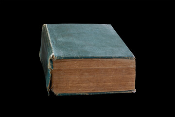 An old thick book with a green torn cover isolated on a black background with