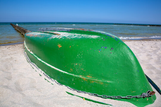 Grünes Ruderboot eines Fischers am Strand der Ostsee