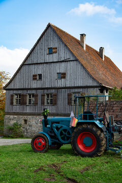 Alter Bauernhof mit Oldtimer Traktor im Vordergrund 