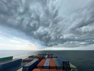 Ultra large container vessel at anchor view on the forward part during stormy weather and grey...