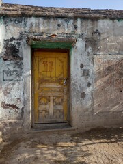 Indian old village house closed yellow door grunge wall