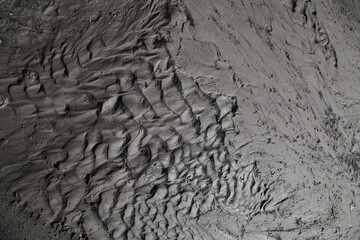 Mud surface texture autumn wet soggy brown black soil earth after rain in the form of natural organic clay and geological mixture.