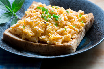 Scrambled eggs on toasted wholegrain bread. Garnished with spring onion.