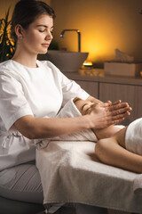 Masseur therapist doing rejuvenating facial massage procedure in a beauty salon. Skin care. Body care. Woman doctor portrait.