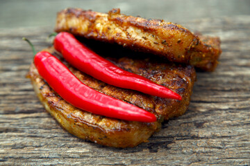 Meat steak cooked on the barbecue. Grilled fresh meat steak with spices and red pepper. Ready steak on the table with tomatoes and peppers. The concept of food, restaurants, traditional cuisine.