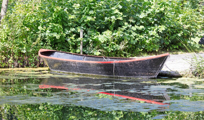Old wooden rowing boat floating