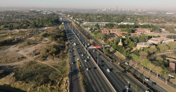 Scenic aerial view of Johannesburg N1 highway traffic. Johannesburg skyline in the background surrounded by smog and pollution