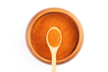 Red chili pepper in wooden bowl and spoon isolated on white. Macro. Flat lay. Vegetarian food concept