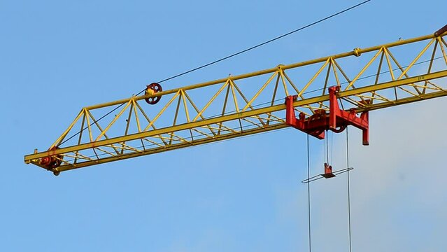 Red crane beam arm on the blue sky with white clouds transfer the heavy cargo object, modern construction site diversity