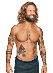 Fototapeta premium Handsome man with beard and long hair standing shirtless showing tattoos angry and mad screaming frustrated and furious, shouting with anger. rage and aggressive concept.
