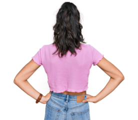 Hispanic teenager girl with dental braces wearing casual clothes standing backwards looking away with arms on body