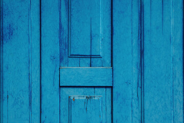 Fragment of an old wooden door painted blue. Background, texture for design.
