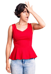 Fototapeta premium Beautiful young woman with short hair wearing casual style with sleeveless shirt surprised with hand on head for mistake, remember error. forgot, bad memory concept.