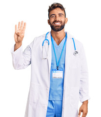 Young hispanic man wearing doctor uniform and stethoscope showing and pointing up with fingers number four while smiling confident and happy.