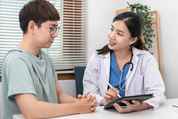 Female doctor physician is taking notes on tablet and writing prescription while asking symptom